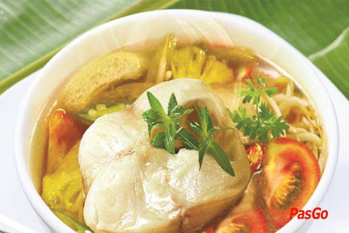 Bát canh cá dứa chua ngọt thanh mát, trang trí bằng hành thì là, sẵn sàng cho bữa ăn.