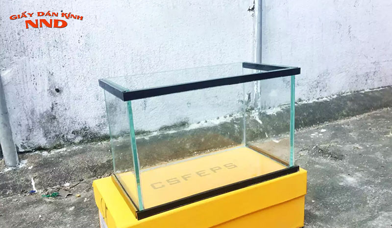 Làm sạch bề mặt kính trước khi dán tranh phong cảnh cho bể cá
