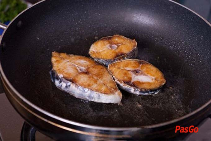Rán sơ cá chép trong chảo dầu nóng giúp miếng cá săn chắc và thơm hơn khi nấu canh chua dứa.