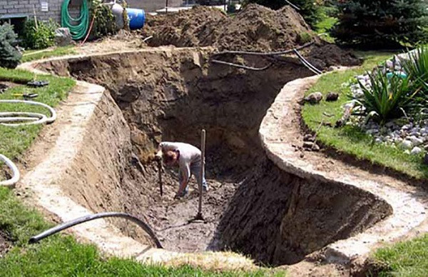 Người thợ đang thi công xây dựng bể cá cảnh xi măng ngoài trời, đảm bảo nền móng vững chắc