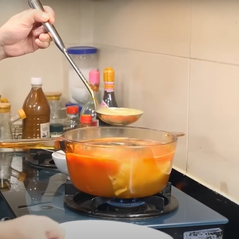 Nồi canh cá chua đang nêm nếm gia vị đậm đà